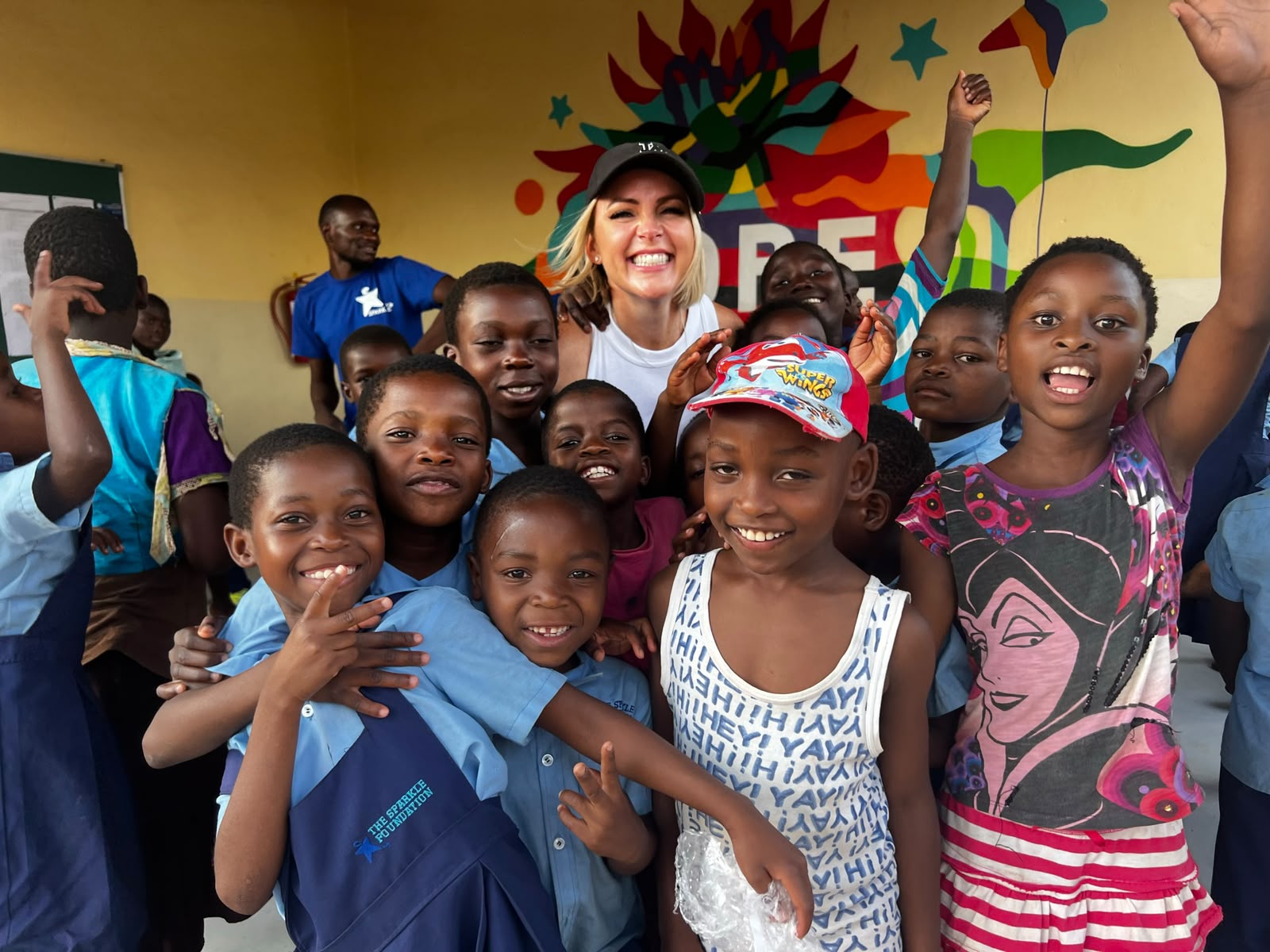 Kelly Lundberg surrounded by smiling children at the Sparkle Foundation in Malawi